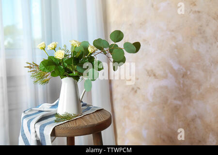 Schöne Blumen in der Kanne auf hellen Hintergrund Stockfoto