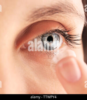 Nahaufnahme der jungen Frau die Kontaktlinsen in den Augen Stockfoto