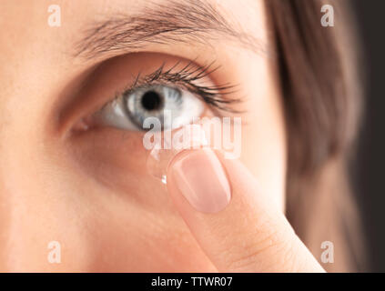 Nahaufnahme der jungen Frau die Kontaktlinsen in den Augen Stockfoto