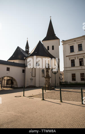 Povyseni kostel sv. Krize Kirche mit Statue des sv. Florian hinter in Karvina Stadt in der Tschechischen Republik während schöner Tag mit klaren Himmel Stockfoto