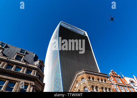 London, UK, 14. Mai 2019: Flugzeug über 20 Fenchurch Wolkenkratzer gegen blauen Himmel fliegen. Es ist auch als Walkie Talkie bekannte Gebäude Stockfoto