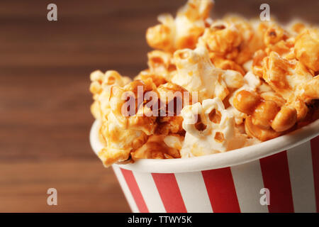 Karamell Popcorn in gestreiften Kasten auf Holz- Hintergrund Stockfoto