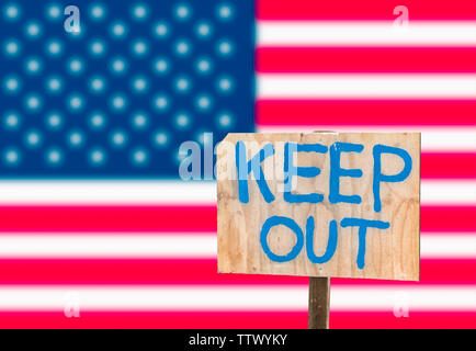 Halten Sie Zeichen vor der USA-Flagge, einer Geschlossenen Grenze und die geplante Mauer zwischen Mexiko und den USA zu bedeuten. Stockfoto