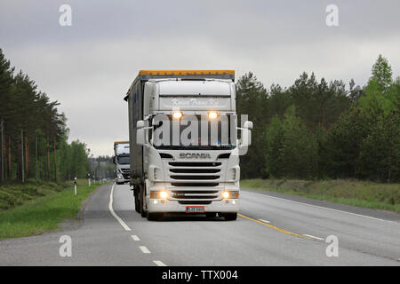 Raasepori, Finnland. Mai 24, 2019: Weiß Scania R 440 Auflieger mit Fernlicht auf Kurz und anderen Lastwagen transportieren Waren auf der Straße im Süden Finnlands. Stockfoto