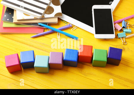 Tablet, copybook und Holzwürfel auf farbigen Hintergrund Stockfoto