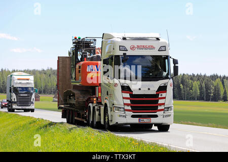 Humppila, Finnland. 31. Mai 2019. Neue Scania R500 Lkw hols Hitachi Zaxis 250 LC Hydraulikbagger auf Anhänger in Highway Traffic am Tag der Sommer. Stockfoto