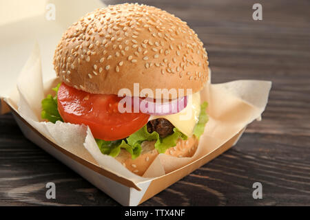 Leckere Cheeseburger im Karton auf Holz- Hintergrund Stockfoto