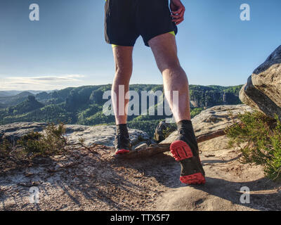 Sportler auf der Spur. Schlanken Körper Mann im gelben Trikot, schwarze Hosen und schwarzen Laufschuhe laufen in der wilden Natur. Stockfoto