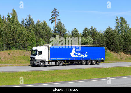 Salo, Finnland. 30. Mai 2019. Seitenansicht des weißen Mercedes-Benz Actros Semi Truck vor blau Anhänger Lkw JSC bei hoher Geschwindigkeit auf der Autobahn im Sommer. Stockfoto