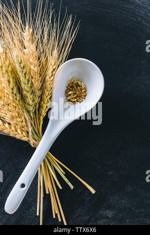 Weizenähren und Mehl auf schwarzem Hintergrund Stockfoto