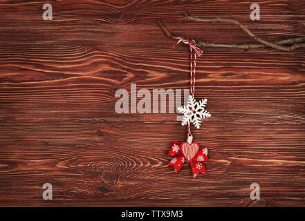 Weihnachtsdekoration hängen auf Zweig gegen Holz- Hintergrund Stockfoto