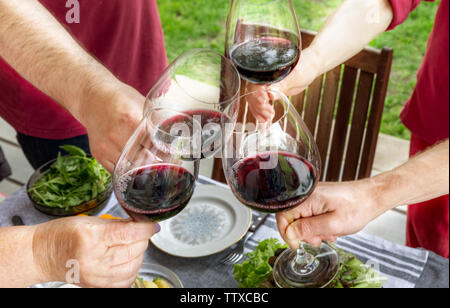 Familie unterschiedlichen Alters Menschen fröhlich feiern im Freien mit Gläser Rotwein, Toast verkünden Stockfoto