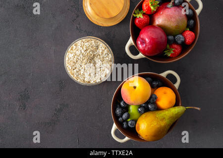 Rohes Getreide mit Obst auf einem dunklen Hintergrund der Ansicht von oben Stockfoto