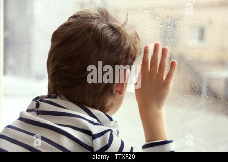 Nahaufnahme der kleine Junge Blick aus Fenster Stockfoto