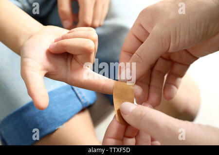 Frau Pflaster um die kleinen Finger wickeln, Ansicht schließen Stockfoto