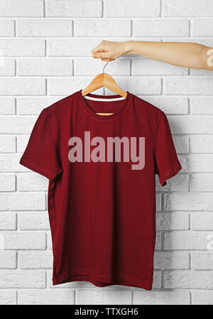 Leere maroon-t-shirt gegen die Mauer Stockfoto