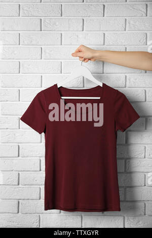 Leere maroon-t-shirt gegen die Mauer Stockfoto