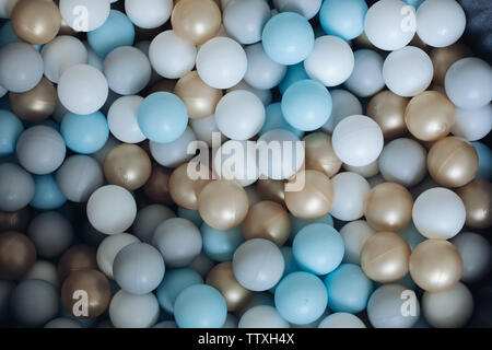 Bunte plastikkugeln von oben. Blick von oben auf die bunten Kugeln aus Kunststoff in einem Haufen Haufen. Weiß, goldenen, blauen, grauen Farben. Stockfoto