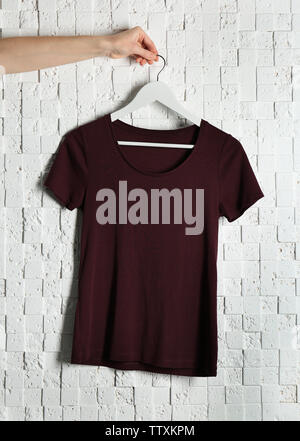 Leere maroon-t-shirt gegen Licht strukturierten Hintergrund Stockfoto