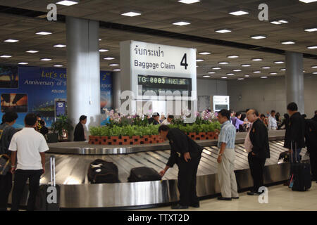 Passagiere, die am Flughafen Suvarnabhumi, Bangkok, Thailand, auf ihr Gepäck warten Stockfoto