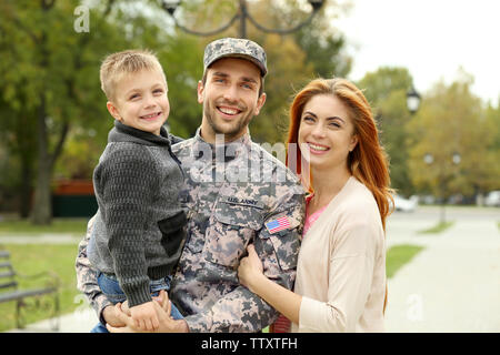 Soldat mit seiner Familie im Park wieder vereint Stockfoto