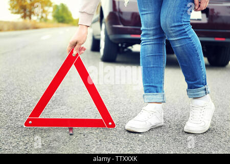 Weibliche Treiber heraus Verkehr Warnschild auf der Straße Stockfoto