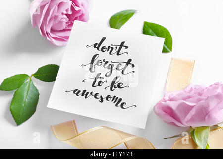 Aufschrift "VERGISS NICHT EHRFÜRCHTIG' auf Papier mit Blumen und Farbband auf weißem Hintergrund geschrieben werden Stockfoto