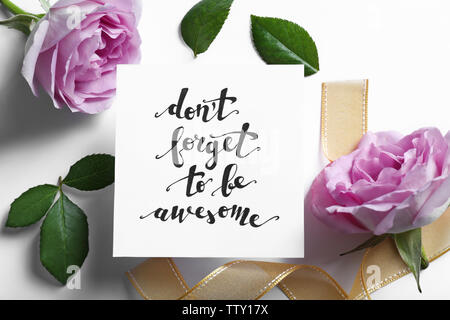 Aufschrift "VERGISS NICHT EHRFÜRCHTIG' auf Papier mit Blumen und Farbband auf weißem Hintergrund geschrieben werden Stockfoto