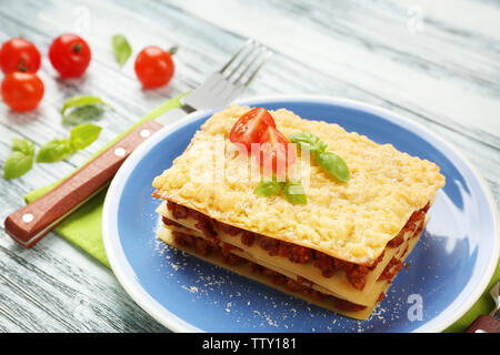 Teil der leckeren Lasagne auf hölzernen Tisch Stockfoto