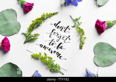 Aufschrift "VERGISS NICHT EHRFÜRCHTIG' auf Papier mit Blumen und Blätter auf weißem Hintergrund geschrieben werden Stockfoto
