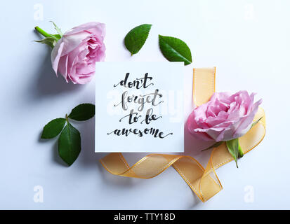 Aufschrift "VERGISS NICHT EHRFÜRCHTIG' auf Papier mit Blumen und Farbband auf weißem Hintergrund geschrieben werden Stockfoto