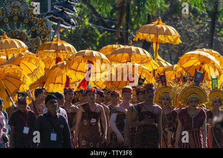 DENPASAR/INDONESIEN - 15. JUNI 2019: Gruppe der Balinesische Tänzerin in ethnischen Kostüme mit traditionellen bunten Schirme am hinduistischen Zeremonie Parade während Templ Stockfoto