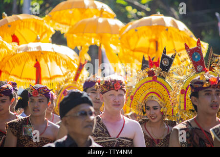 DENPASAR/INDONESIEN - 15. JUNI 2019: Gruppe der Balinesische Tänzerin in ethnischen Kostüme mit traditionellen bunten Schirme am hinduistischen Zeremonie Parade während Templ Stockfoto