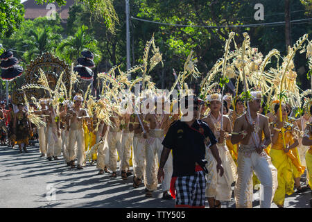 DENPASAR/BALI - 15. JUNI 2019: Sampian Tänzerin, die in gelben und weissen Tracht, Wandern im Bali Arts Festival 2019 durchzuführen. Sie verwenden die Palm Stockfoto