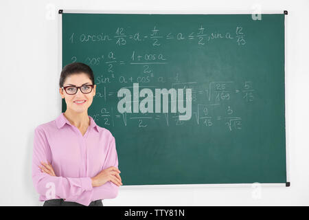 Junge weibliche Lehrer neben Blackboard auf weißem Hintergrund Stockfoto