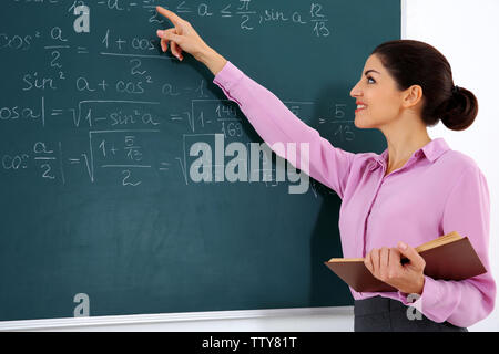 Junge weibliche Lehrer neben Blackboard auf weißem Hintergrund Stockfoto