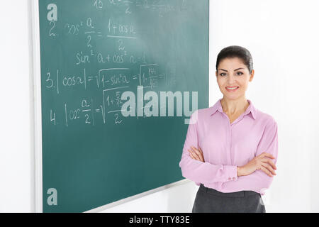 Junge weibliche Lehrer neben Blackboard auf weißem Hintergrund Stockfoto