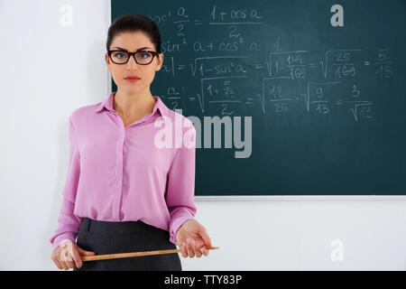 Junge weibliche Lehrer neben Blackboard auf weißem Hintergrund Stockfoto