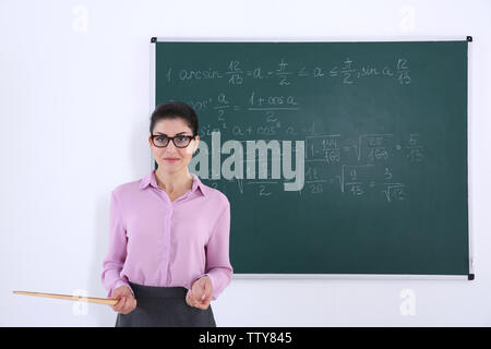 Junge weibliche Lehrer neben Blackboard auf weißem Hintergrund Stockfoto