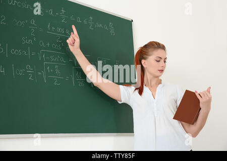 Junge Lehrer neben Blackboard auf weißem Hintergrund Stockfoto
