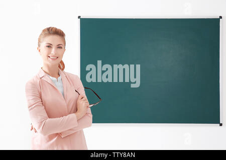 Junge Lehrer neben Blackboard auf weißem Hintergrund Stockfoto