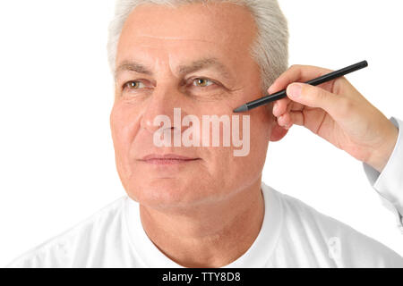 Weibliche hand Zeichnung Korrekturposition auf das Gesicht des Mannes auf weißem Hintergrund Stockfoto