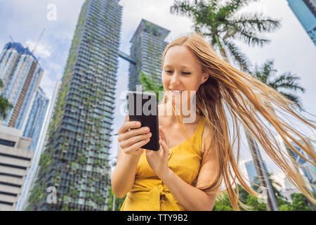 Frau Tourist können Sie über die Navigation App auf dem Handy. Navigation Karte auf einem Smartphone in einer großen Stadt Stockfoto