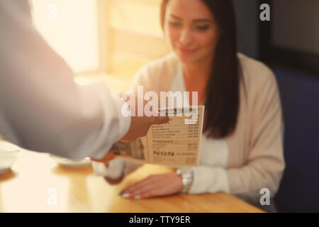 Hand der Kellner, Menü, um junge Frau, Ansicht schließen Stockfoto