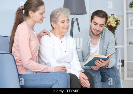 Großmutter mit Enkel lesen Buch auf dem Sofa Stockfoto