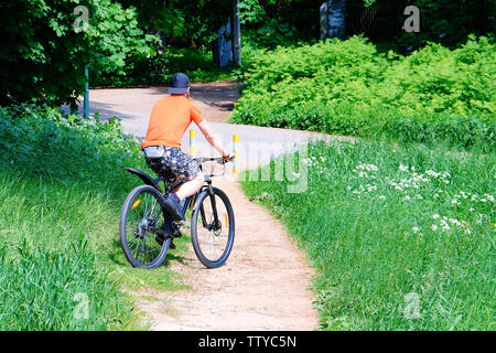 Der Fahrradfahrer im Park erhielt einen Anruf. Gestoppt am Telefon zu sprechen Stockfoto