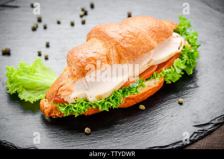 Köstliche Croissants mit Huhn füllen auf einem Schwarzen Tisch Stockfoto