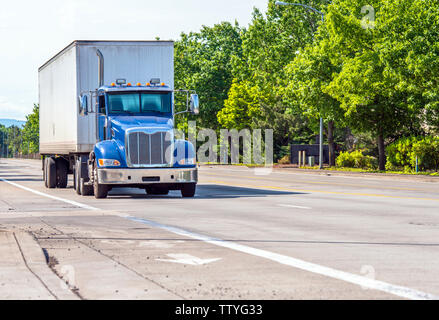 Blau leistungsstarke kompakte Motorhaube Industrial Grade Big Rig Tag cab Semi Truck für den lokalen Transport Transport von kommerziellen Ladung in trockenen van Auflieger runn Stockfoto