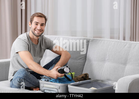 Der Mensch seine grauen Koffer im Wohnzimmer Stockfoto