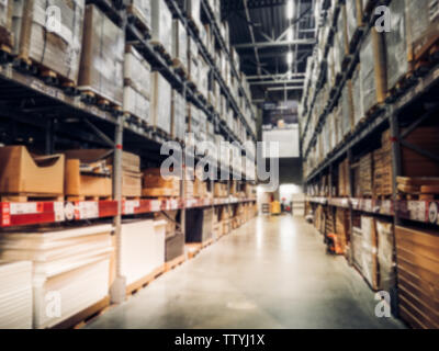 Unscharfer Kisten auf regalreihen in warmes Licht warehouse Hintergrund. Für Mock up Vorlage für Handwerk Anzeige von Ihrem Design, Banner für Werbung Stockfoto